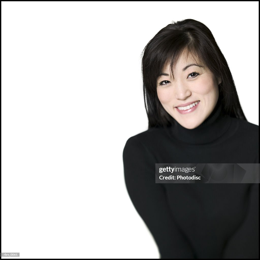 Medium shot of a young adult woman in a black sweater as she smiles
