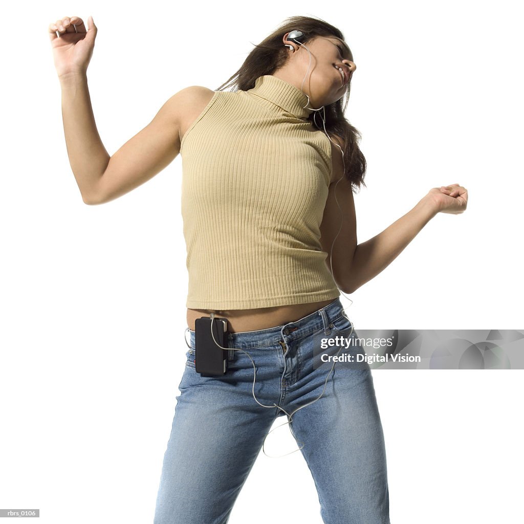 Medium shot of a teenage girl as she dances while listening to headphones