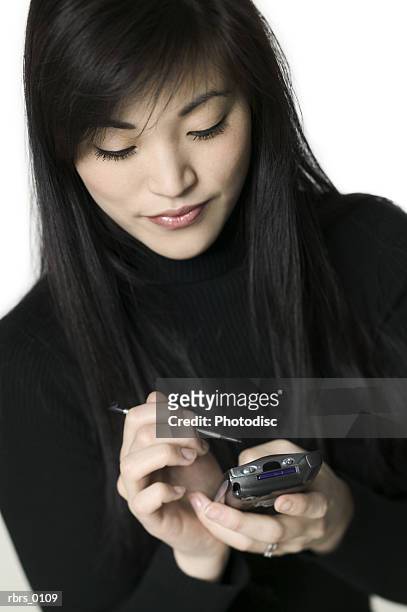 medium shot of a young adult woman as she uses her pda - uses stock pictures, royalty-free photos & images