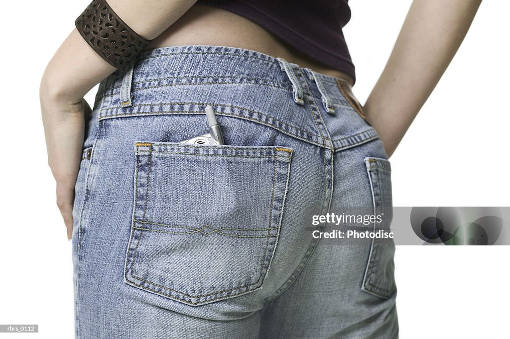 Close up shot of a small cell phone in the back pocket of a teenage female