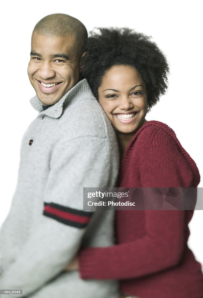 Medium shot of a young adult couple as the woman leans against the man and smiles