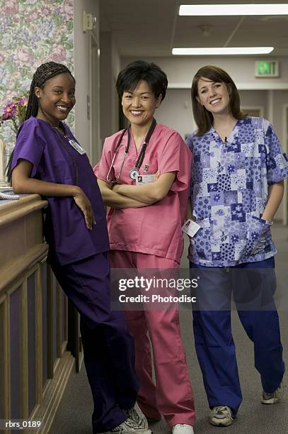 lifestyle shot of three female nurses in a hospital hallway as they smile at the camera - smile bildbanksfoton och bilder