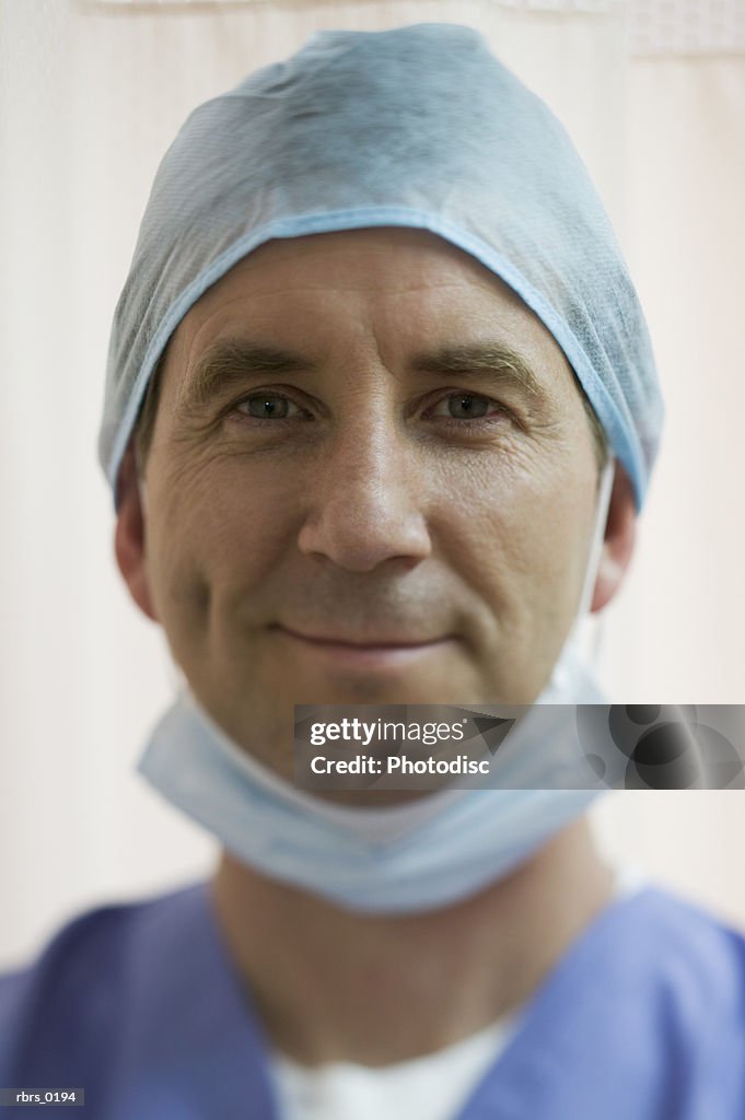 Lifestyle portrait of an adult male doctor in surgical gear as he looks at the camera