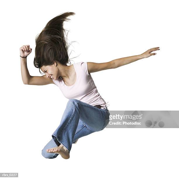 full body portrait of a teenage female in jeans and a pink shirt as she jumps through the air - full body isolated bildbanksfoton och bilder