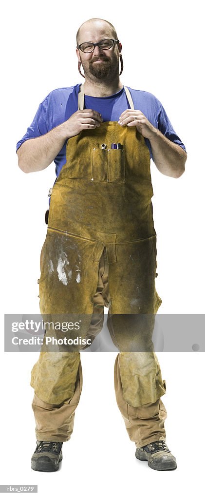 Real people full body portrait of an adult man in work overalls as he looks confidently at the camera