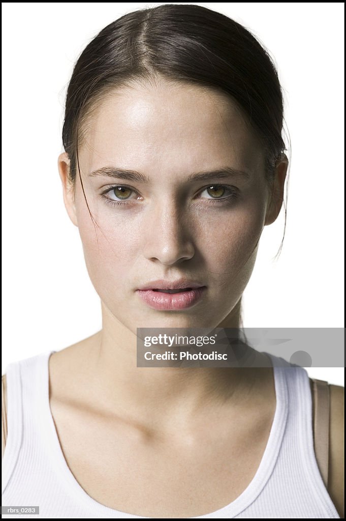 Beauty portrait of a young adult woman in a white tank top as she looks into the camera