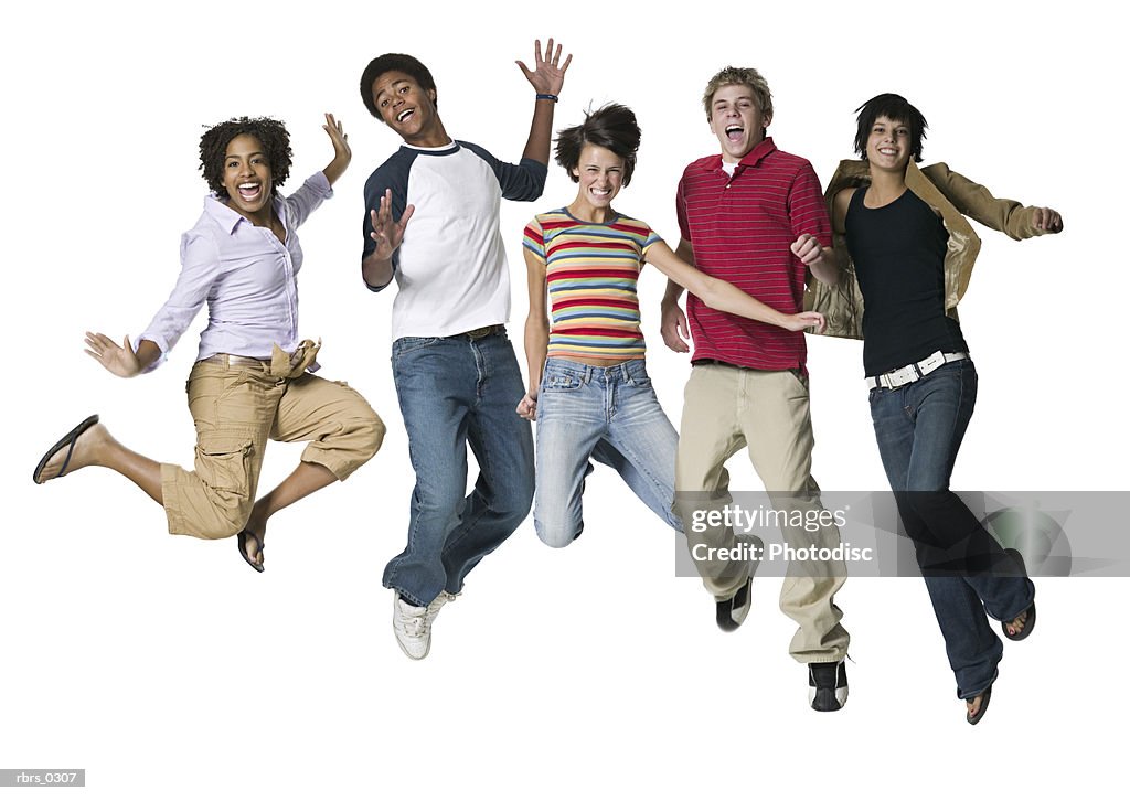 Full body portrait of a group of five teenagers as they all jump up in the air