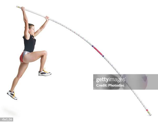 a young caucasian female athlete wearing a black and red uniform is starting a pole vault - salto con pértiga fotografías e imágenes de stock