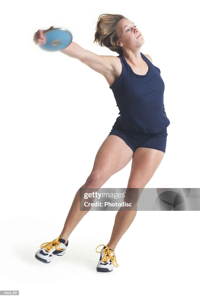 A young caucasian female athlete is wearing a dark uniform and about to throw a discus