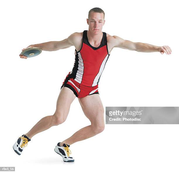 a young caucasian man wearing a red track uniform is preparing to throw a discus as he spins on one foot - mens field event 個照片及圖片檔