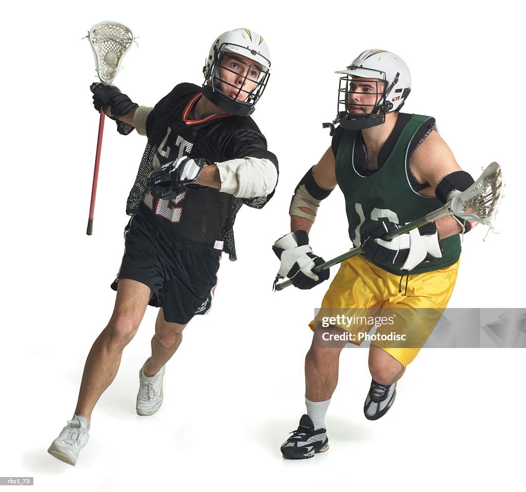 Two caucasian male lacrosse players from opposite teams run as the one in the green jersey tries to block the one in black