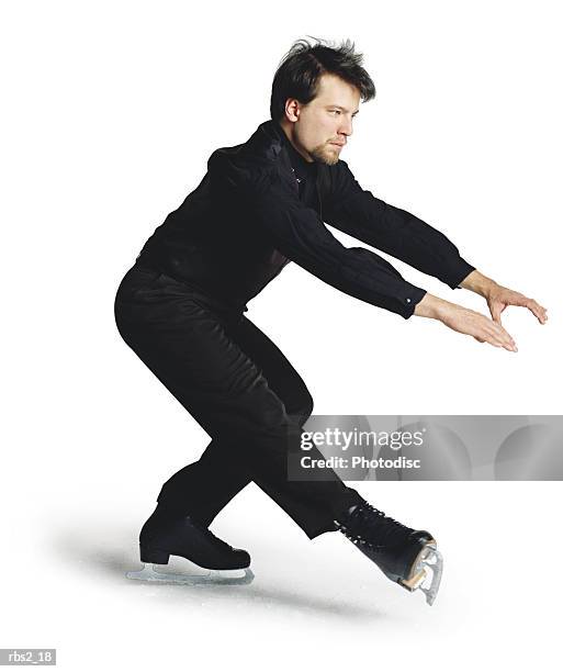 a young caucasian man wearing a black ice skating suit and ice skates is spinning around - figure skater stock pictures, royalty-free photos & images