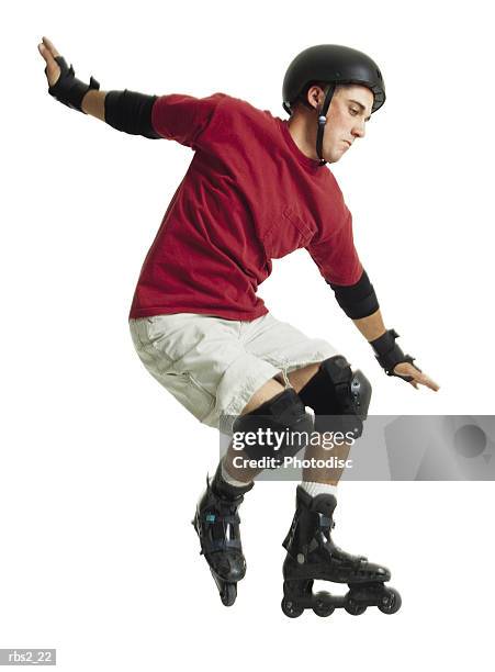 a young caucasian male in a red shirt and a black helmet rollerblades and jumps forward while balancing himself with his arms - indoor skating stock pictures, royalty-free photos & images