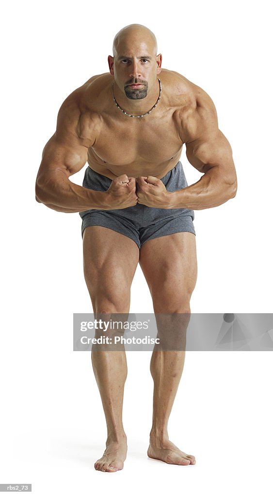 Adult caucasian male bodybuilder shows off muscles holding his arms down flexing arms and chest