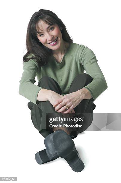 a caucasian woman dressed in green pants and blouse sits down and smiles - down blouse stock pictures, royalty-free photos & images