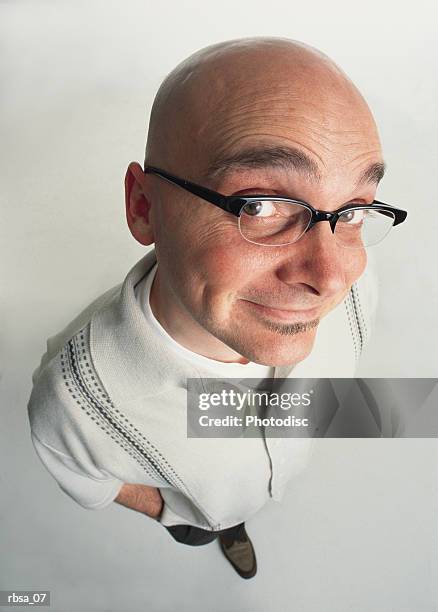 bald young adult caucasian male with facial hair and glasses stands looking up at the camera with an expressive grin - soul patch stock pictures, royalty-free photos & images
