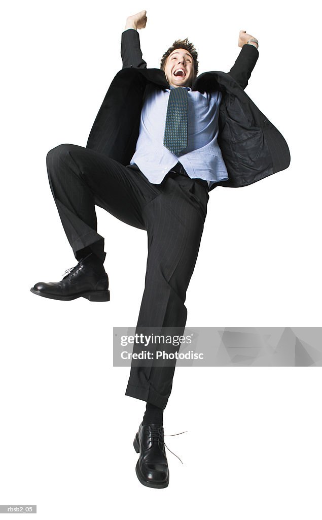 Low angle of a young caucasian man in a suit as he throws up his arms in celebration