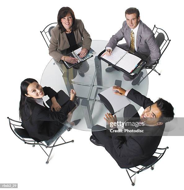 group of business people sit around a table in staff meeting as they look up and smile to camera - smile imagens e fotografias de stock