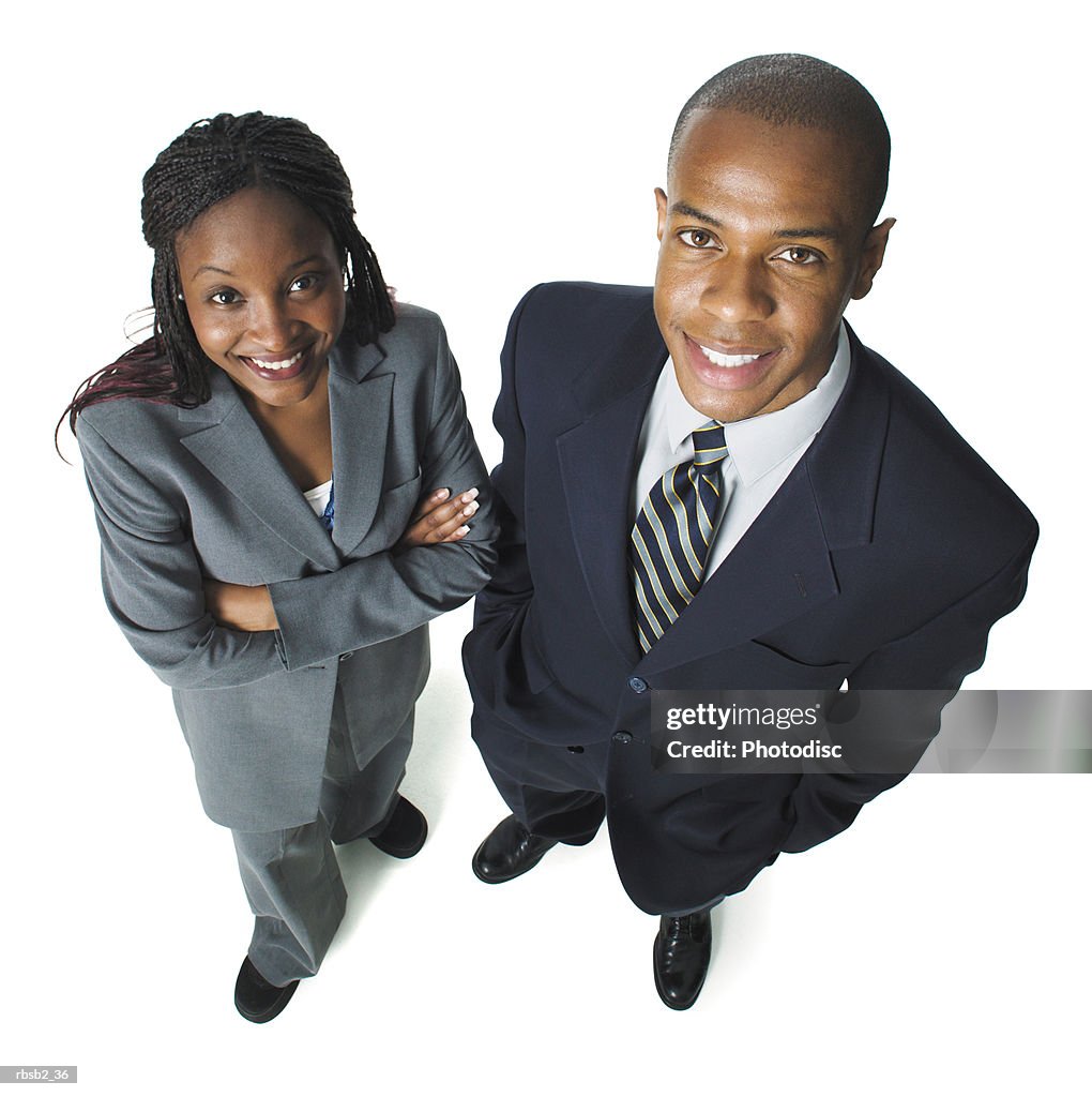 Two young african american business people stand side by side smiling up at the camera