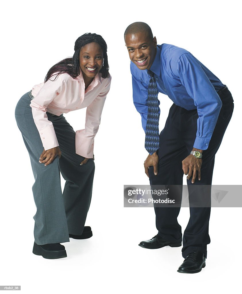 Two young african american business people crouch down and playfully smile