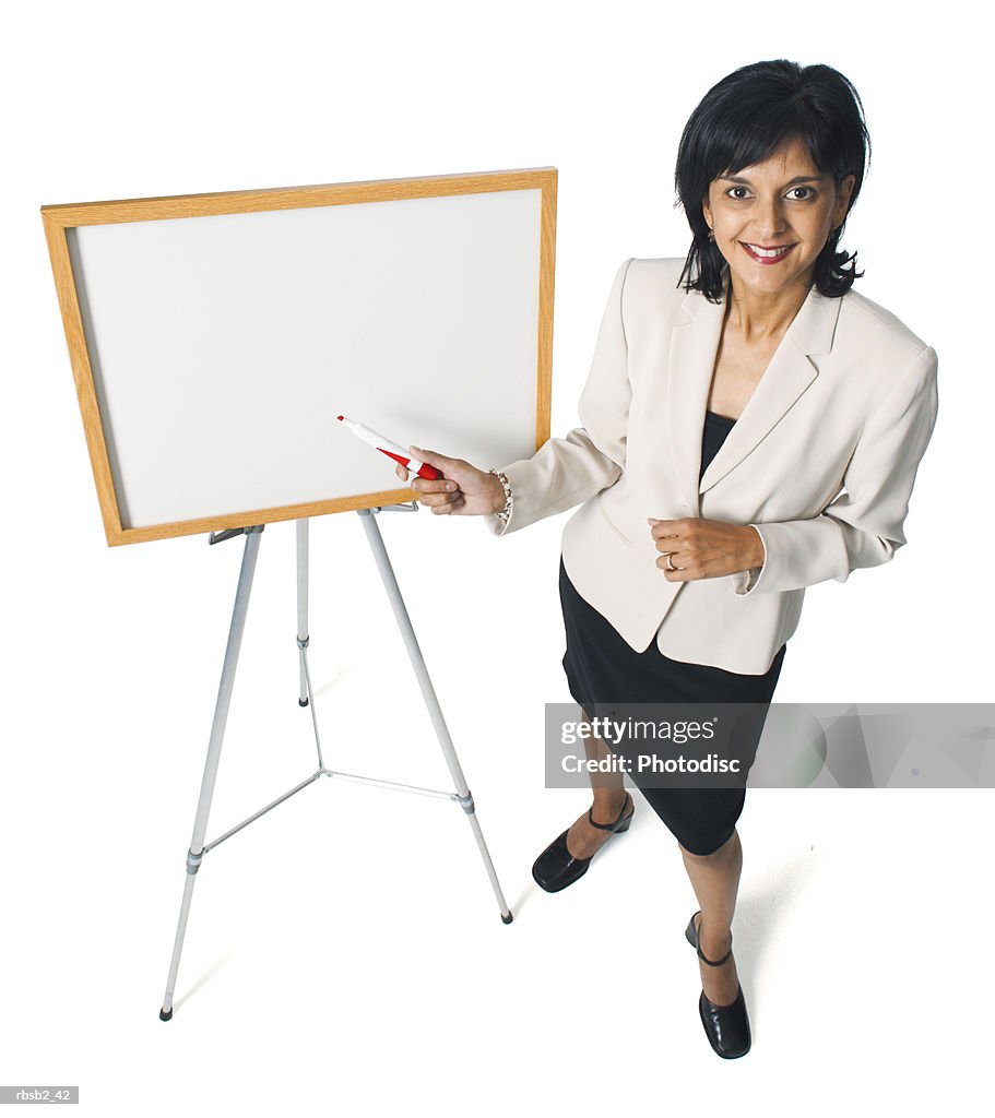 An attractive ethnic business woman points at a display board while giving a presentation