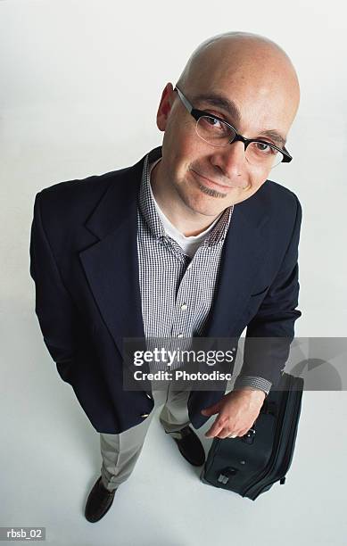 young caucasian bald man with glasses and a goatee in a blue blazer and tan pants with a checkered shirt looking up at the camera his arm leaning on a suitcase - soul patch stock pictures, royalty-free photos & images