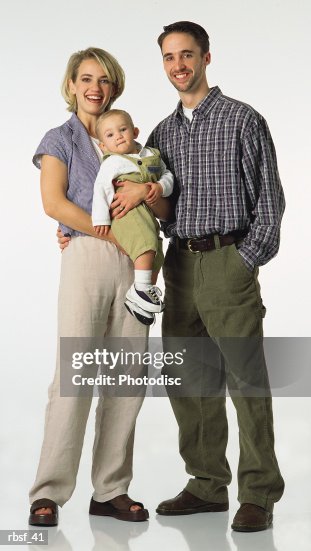 Happy caucasian preppy couple and their baby stand together Happy caucasian preppy couple and their baby stand together