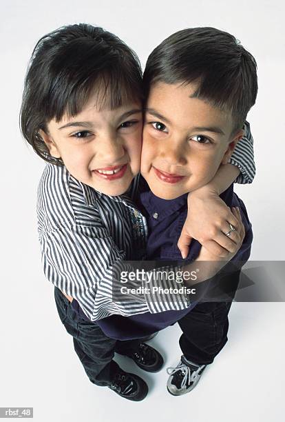 young cute ethnic siblings hug each other and smile - smile stockfoto's en -beelden