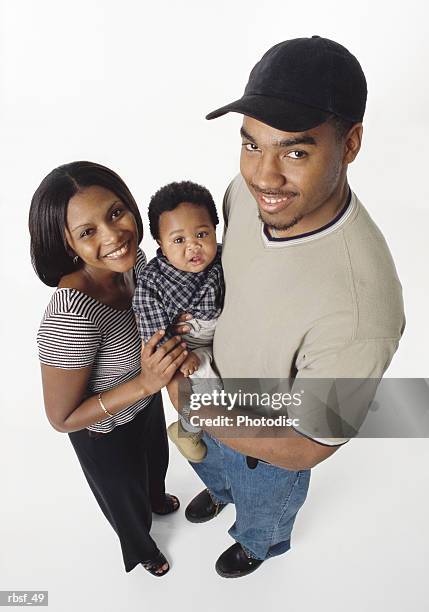 young african american couple smile and hold infant between them - smile stockfoto's en -beelden