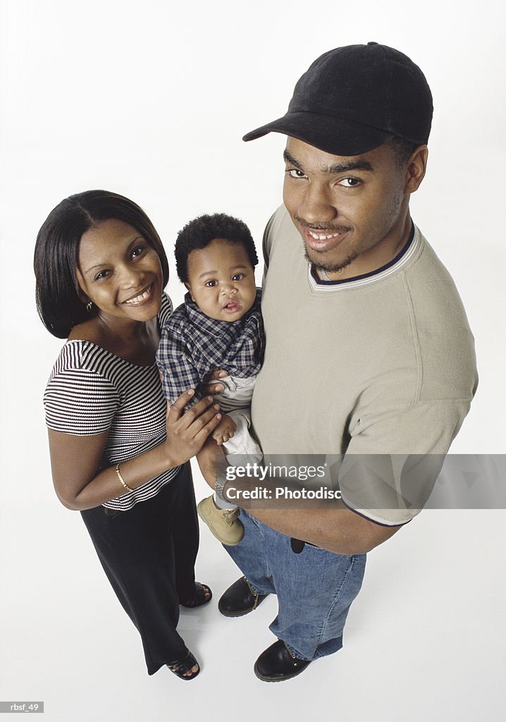 Young african american couple smile and hold infant between them