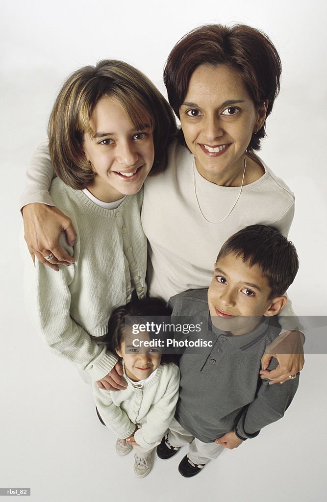 Ethnic family mom with her arms around her three young kids