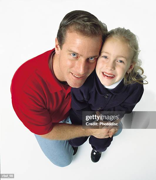 caucasian dad on one knee holds his blonde daughter while both smile big - smile imagens e fotografias de stock