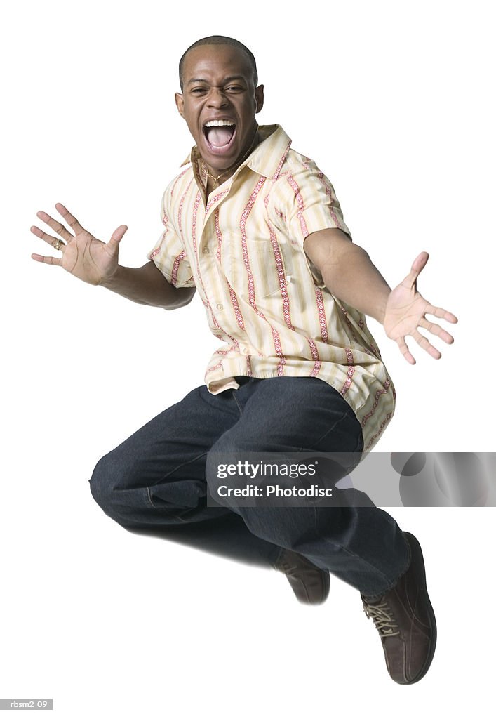 A young adult male in jeans and a striped shirt jumps up playfully into the air