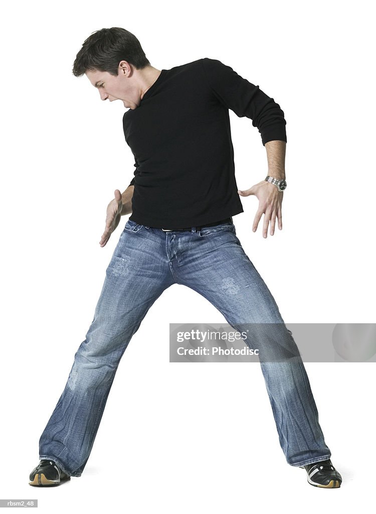 A young adult male in jeans and a black shirt as he dances around