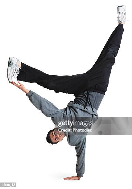 young male breakdancer black pants grey top flips upside down balances on his hand legs in the air - pants down bildbanksfoton och bilder