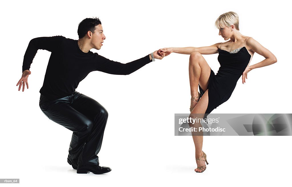 Young latin male and young caucasian blonde female dance partners tango dressed in black