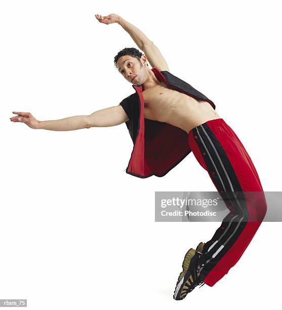 a young latin male modern dancer in red pants and a black vest and no shirt arches his back and balance on his tiptoes - roupa de discoteca imagens e fotografias de stock