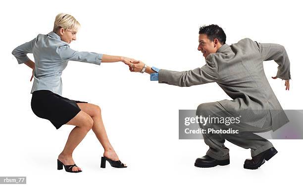 a young latin business man in a grey suit holds out his hand and dances with a young caucasian blonde female in a black skirt and blue blouse - swing dancing stock-fotos und bilder