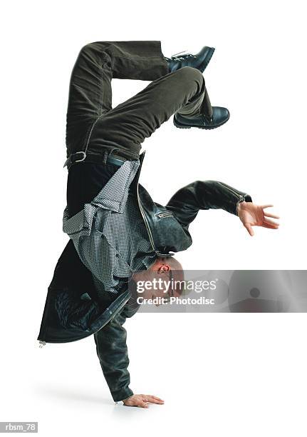 young bald male modern dancer in green pants and leather jacket balances upside down on one hand - pants down bildbanksfoton och bilder