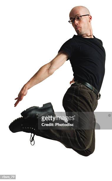 a young caucasian bald male modern dancer dressed in black and wearing glasses jumps up twists his body and reaches for his feet - black male feet fotografías e imágenes de stock