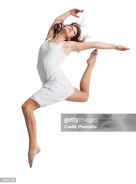 a young female dancer in a white dress runs and leaps forward as she throws her arms and head back - head forward white background imagens e fotografias de stock