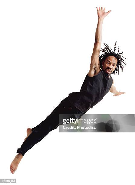 a young african american male modern dancer with dreadlocks dressed in black flies through the air and dives sideways - barefoot black men stock pictures, royalty-free photos & images