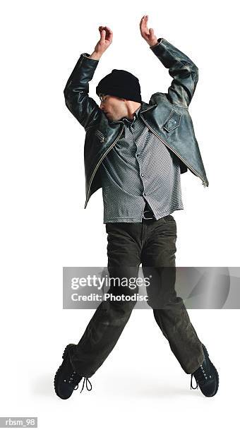 young male modern dancer in black leather jacket knit cap balances on toes raises his arms overhead - roupa de discoteca imagens e fotografias de stock