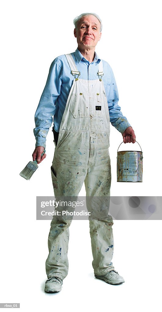 An elderly caucasian painter stands with his brush and paint bucket