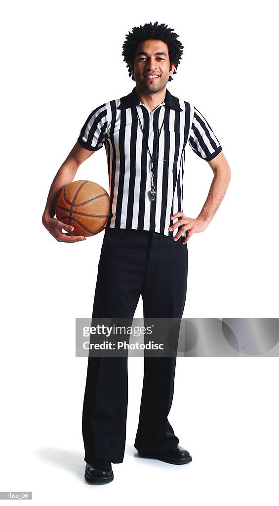 A young african american referee stands with a basketball smiling