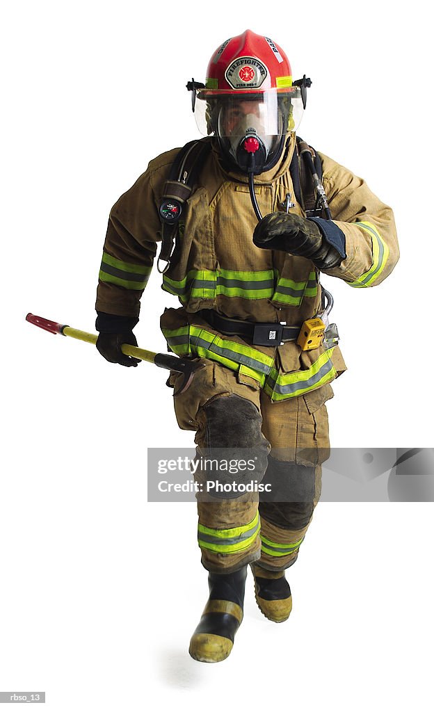 A firefighter in full gear runs forward carrying a fire axe