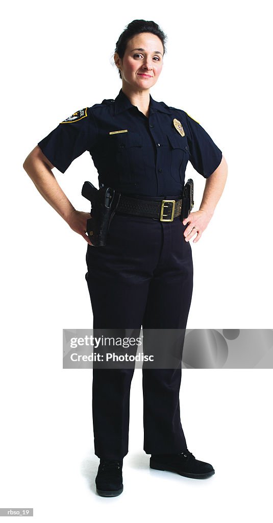 A caucasian police woman stands with her hands on her hips