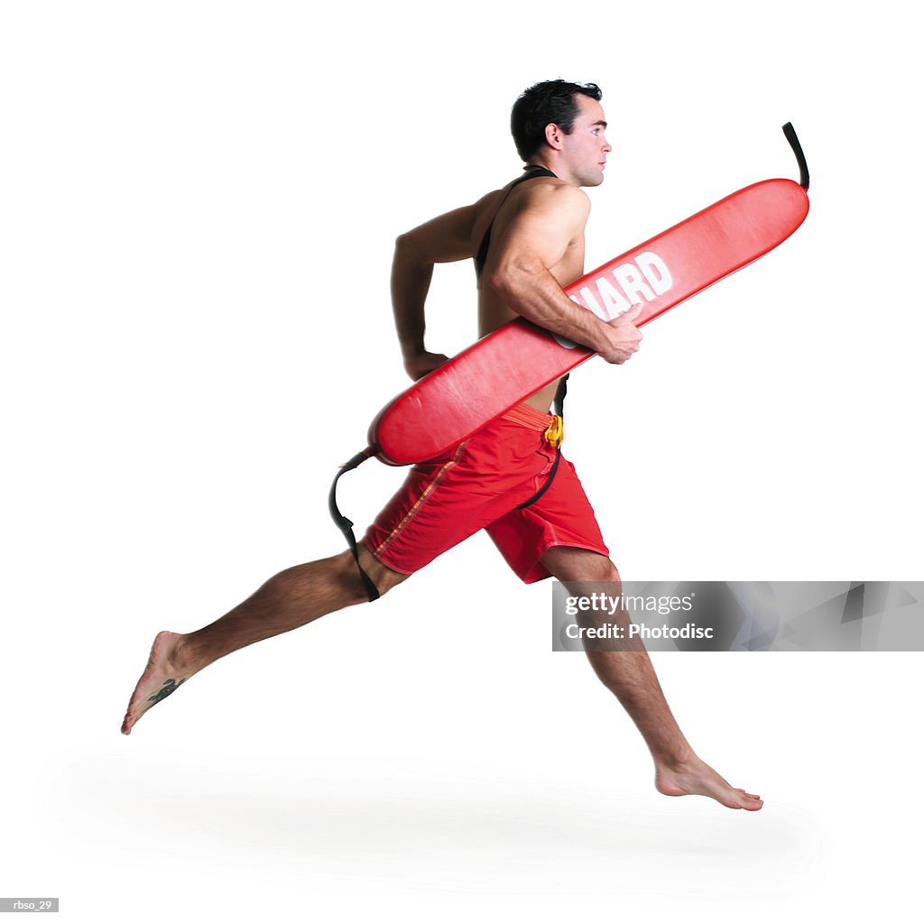 A young caucasian male lifeguard runs quickly with his rescue tube