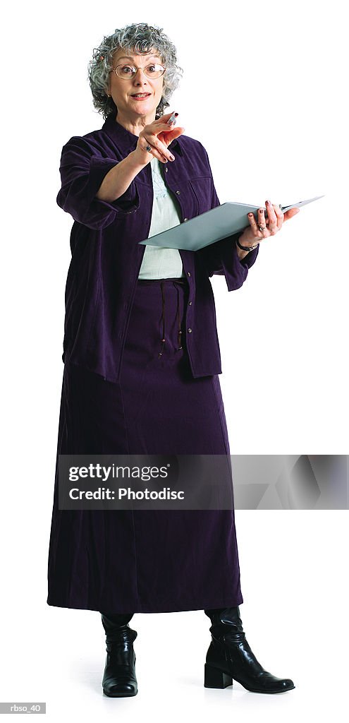 An elderly caucasian female instructor teaches while holding a notebook