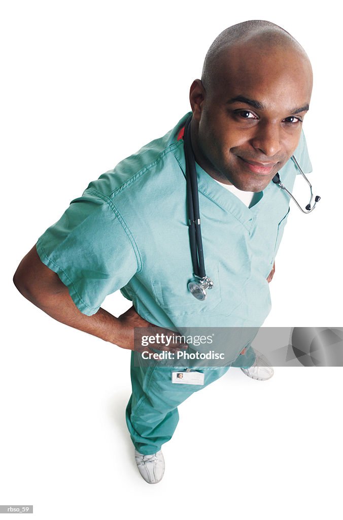 A young african american male nurse dressed in scubs smirks as he looks up at the camera